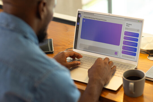 Using AI chatbot on laptop, man working on digital marketing project at home office desk