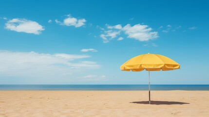 Fototapeta premium A single yellow umbrella on a vast, empty sandy beach with clear blue skies above