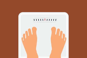 Top view of feet of woman standing on bathroom scales
