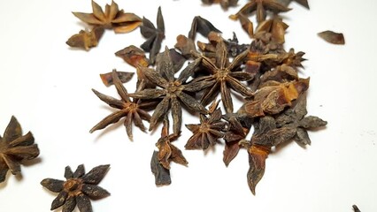 Dried star anise flower falling on isolated white background, food cooking seasoning video concept.