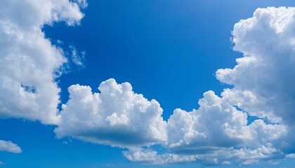 Obraz premium Bright blue sky with white lush clouds. natural landscape, ideal for illustrating atmospheric phenomena and the beauty of nature, background, calendars, weather