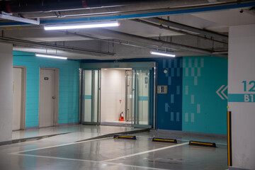 Modern architecture’s underground parking lot and glass entrance to the building
