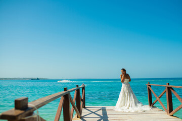 joven mujer en la playa con su traje de bodas en verano 