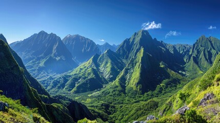 A stunning mountain range with sharp peaks and lush green valleys, under a clear blue sky.