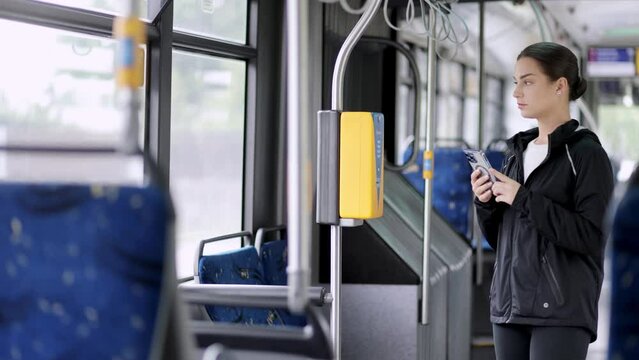 A woman pays with a card for travel on public transport. Concept of travel, trips and public movements.