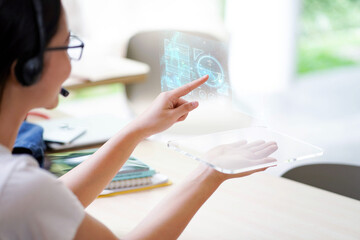 Closeup And crop young Asian female holding and used transparence tablet computer working with lit by engineer HUD interface. GUI (Graphical User Interface) and Future technology concepts.