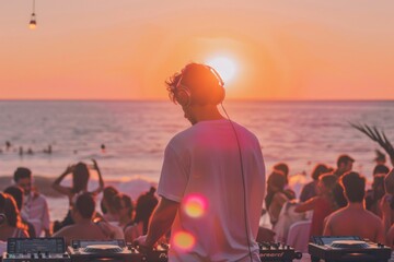 Obraz premium DJ playing music in front of crowd at sunset at a sea view party venue.