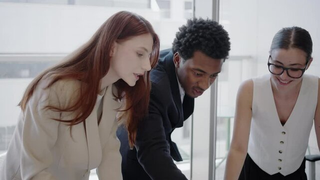 A diverse team of young entrepreneurs gathers in an office, using brainstorming and strategic planning to achieve business goals and find innovative solutions through collaboration