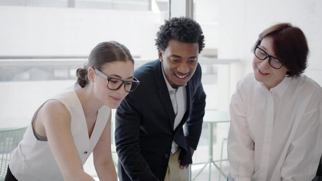 In a modern office environment, young professionals collaborate with teamwork, brainstorming, leadership, and creative ideas to boost synergy and create a positive work atmosphere