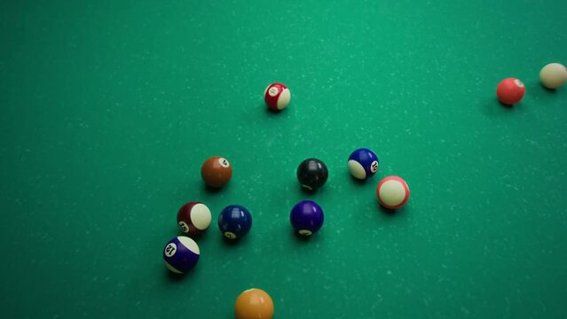 No people top view slowmo of white ball hitting set up triangle with balls when breaking in pool game on green table