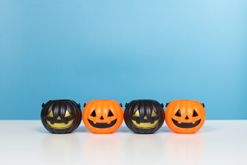 Halloween and decoration concept. Pumpkins orange and black on table with blue background. Jack o lantern pumpkin decoration on wooden table