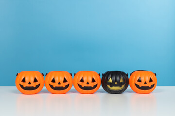 Halloween and decoration concept. Pumpkins orange and black on table with blue background. Jack o lantern pumpkin decoration on wooden table