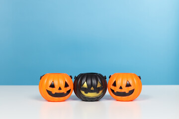 Halloween and decoration concept. Pumpkins orange and black on table with blue background. Jack o lantern pumpkin decoration on wooden table