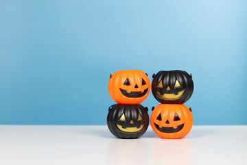 Halloween holiday concept. Stack of Pumpkin orange and black on blue background. Jack o lantern pumpkin decoration on wooden table with copy space