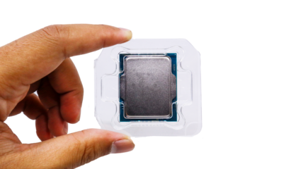 A close-up shot of a CPU processor in its plastic packaging, held in a hand against a white background. Brand new CPU Processor chip tray backgrounds.