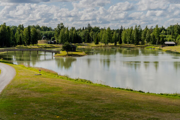 Lake in the park with water surface reflection. Green tree forest