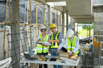 Engineers discussing about new project plan with architect at construction site