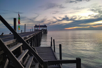 Enjoying the beach atmosphere at sunset on the wooden pier bridge of Maratua Island., East Kalimantan