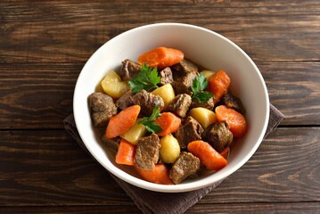 Stewed beef with potatoes, carrots and spices in bowl