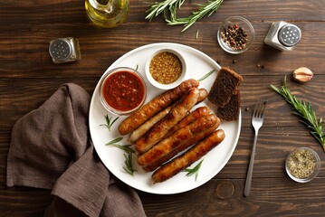 Grilled thin sausages served with tomato sauce and mustard