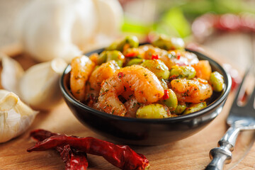 Fresh salad with shrimps and edamame soybeans in bowl on wooden table.