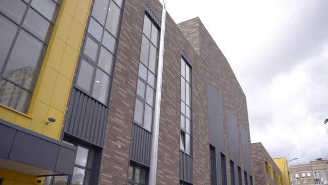 Contemporary facade of school features panoramic windows. Asymmetrical design adds unique and modern touch to exterior of building