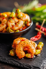 Fresh salad with shrimps and edamame soybeans on black cutting board.