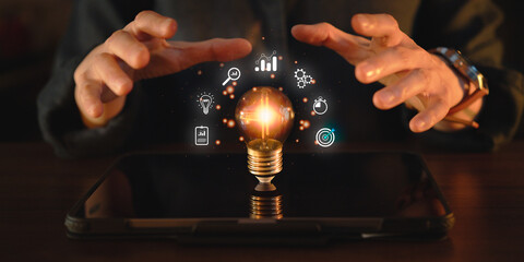 Hands gesturing around a glowing lightbulb, symbol of innovation and technology, intelligence, startup, entrepreneur, creative thinking, business ideas towards success