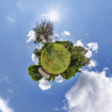 simple tiny planet with wooden home or homestead building in blue sky with beautiful clouds. Transformation of spherical panorama 360 degrees. Spherical abstract aerial view. Curvature of space.