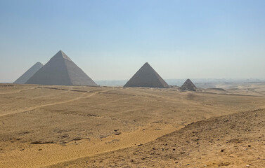 Pyramids of Giza with blue sky and desert in the foreground