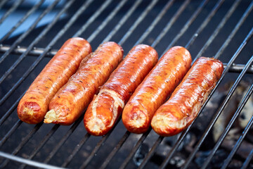 Sausages are grilled on a barbecue grill