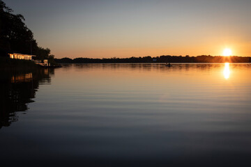 Obraz premium Serene Sunset Over Calm Lake with Reflection
