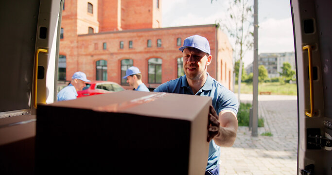 Two Couriers Loading Cardboard Boxes For Moving Service; Transporting Goods