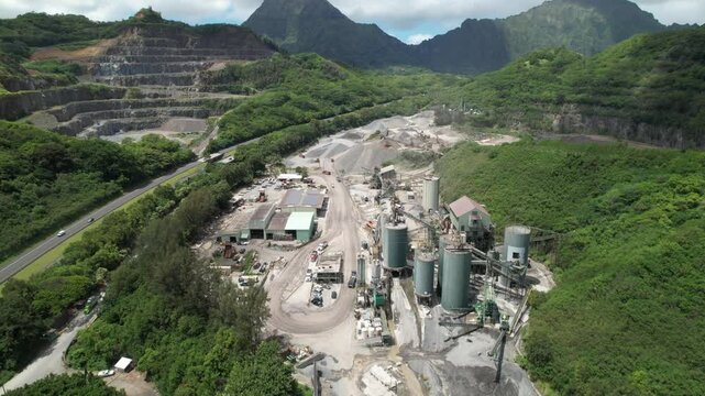 Aerial video of quarry on the island of Oahu, Hawaii - Drone shot flying up for high angle view bluestone and lava rock mining operation in Hawaii.