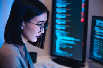 Asian woman  software development working on coding  computer screen and flowchart at night in...