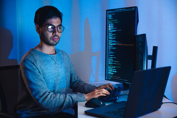 Indian software development working on coding  computer screen and flowchart at night in modern...
