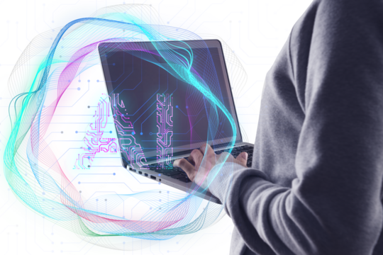 A person using a laptop with colorful abstract digital waves overlayed symbolizing technology and data on a white background