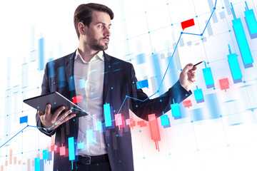 A businessman analyzing digital financial charts, holding a tablet, with a futuristic interface overlay on top