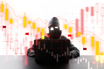 A silhouette of a hooded hacker with a laptop in front of digital financial graphs, depicting cybercrime in finance