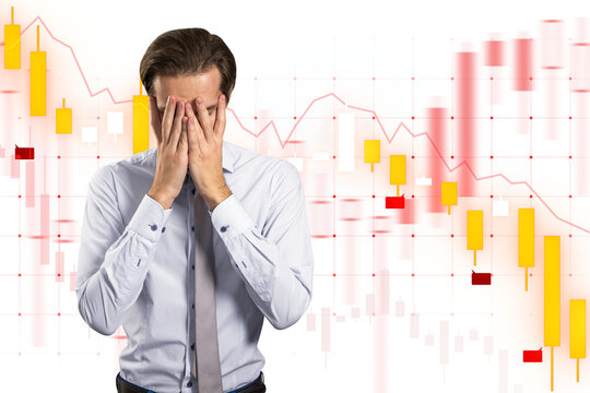 Man with hands on face expressing stress against financial chart backdrop, symbolizing business frustration