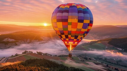 Fototapeta premium Vibrant hot air balloon floats above misty valleys during a golden sunrise providing a breathtaking background for uplifting promotional materials.