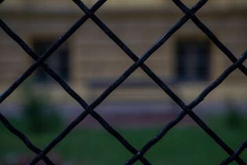 Black wire one centimeter thick. Wire on the prison fence. Blurred background.
