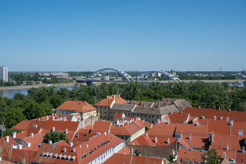 Obraz premium Aerial view of the red roofs of the houses, the river and the white bridge in the background.