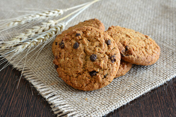 an american cookie with chocolate chips on the table decorated with wheat 