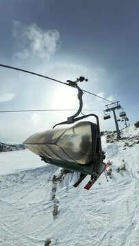 Vertical shot following a chair lift from behind during winter in the austrian Alps

