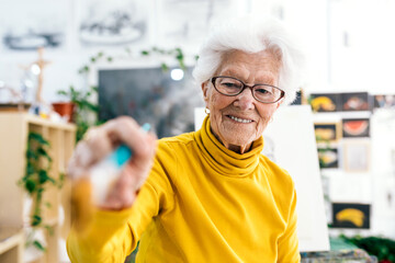 Senior woman holding a paintbrush in art studio