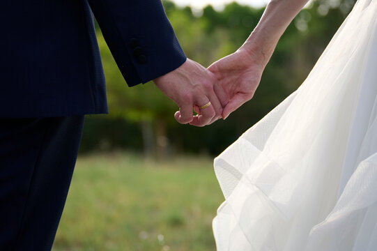 Holding hands at a wedding ceremony outdoors