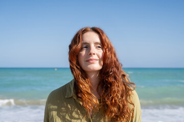 Woman with red hair enjoying the sun at the beach