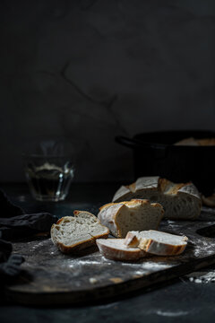 Sliced artisan bread on a rustic kitchen table. Generative AI image
