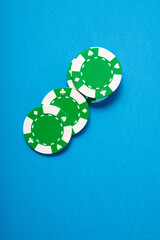 Green casino chips on a blue surface